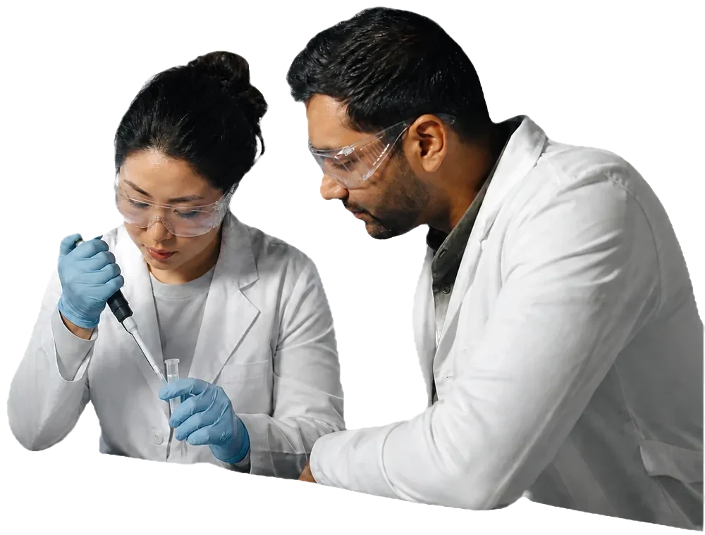 Two laboratory scientists collaborate while preparing a sample.